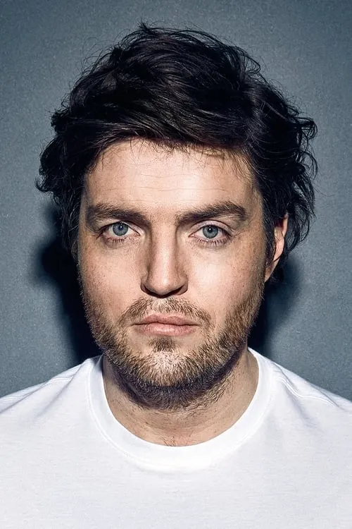 Tom Burke interpretando a Fletcher Dennis