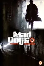 Sheridan Morley interpreta a Newscaster en Mad Dogs